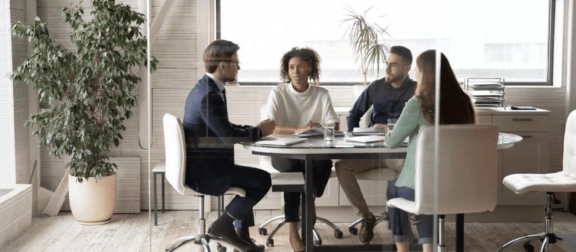 Four professionals sit around a conference room table